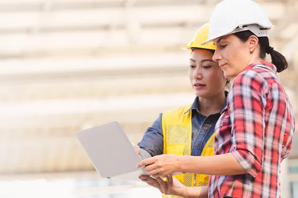 Two construction workers looking at a laptop
