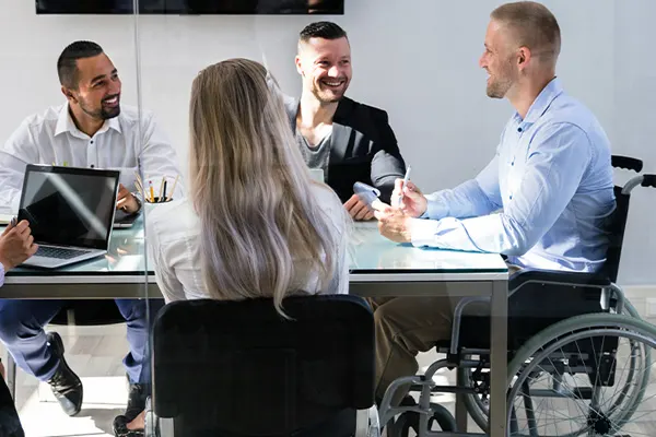 Employees talking at a table THUMBNAIL