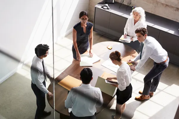 Six executives overhead shot standing around a table