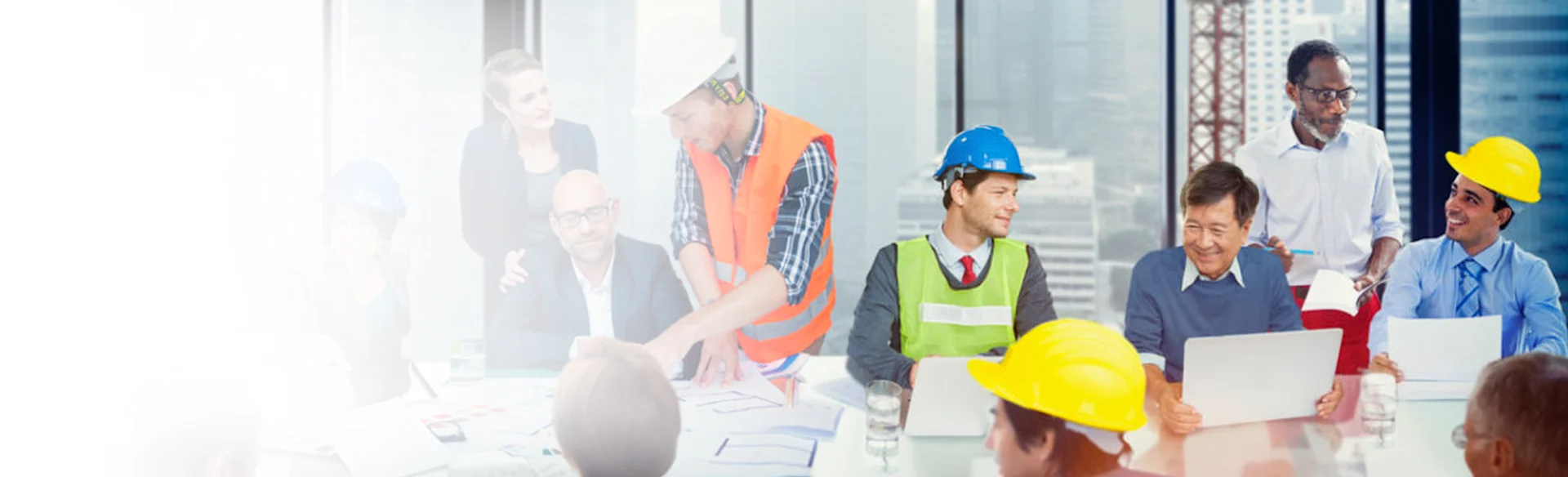 Construction workers at a table talking and looking at drawings 1200x400