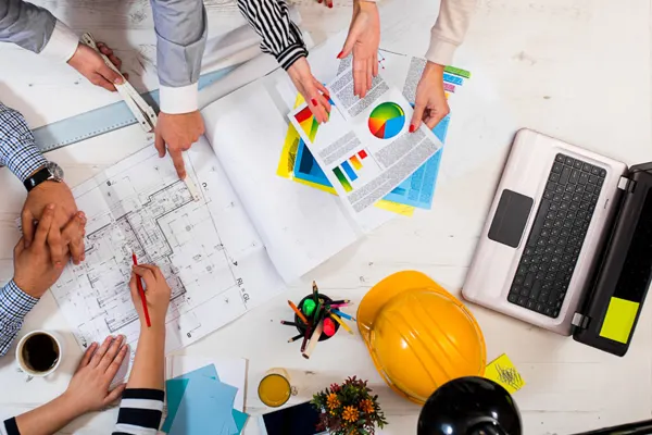 Over head shot of executives looking at drawings and chart THUMBNAIL