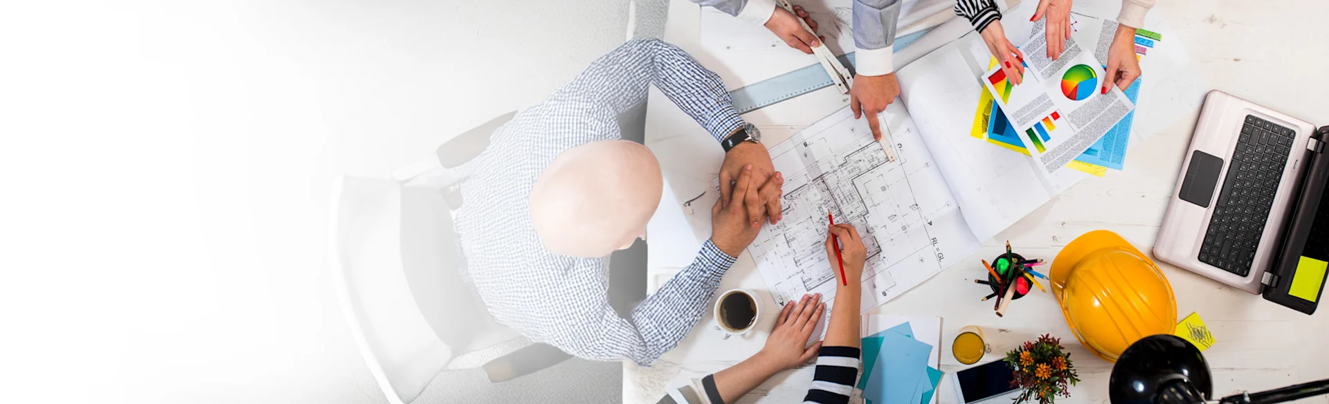 Over head shot three executives looking at drawings 1200x900