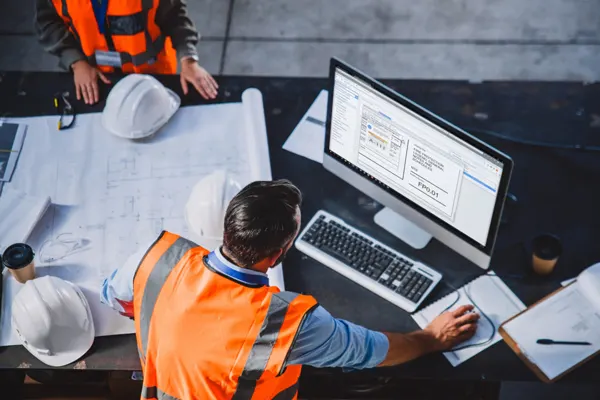 Overhead shot of construction worker looking at monitor THUMBNAIL