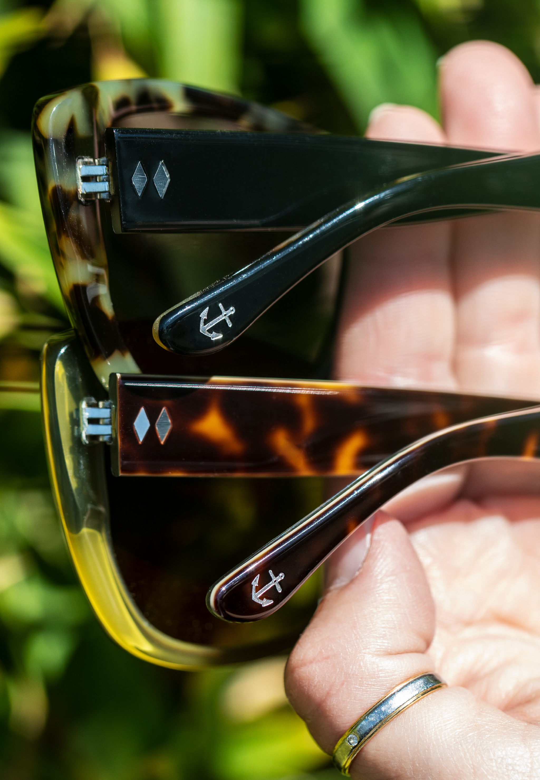 close-up of two Petrillo sunglasses stacked on a hand