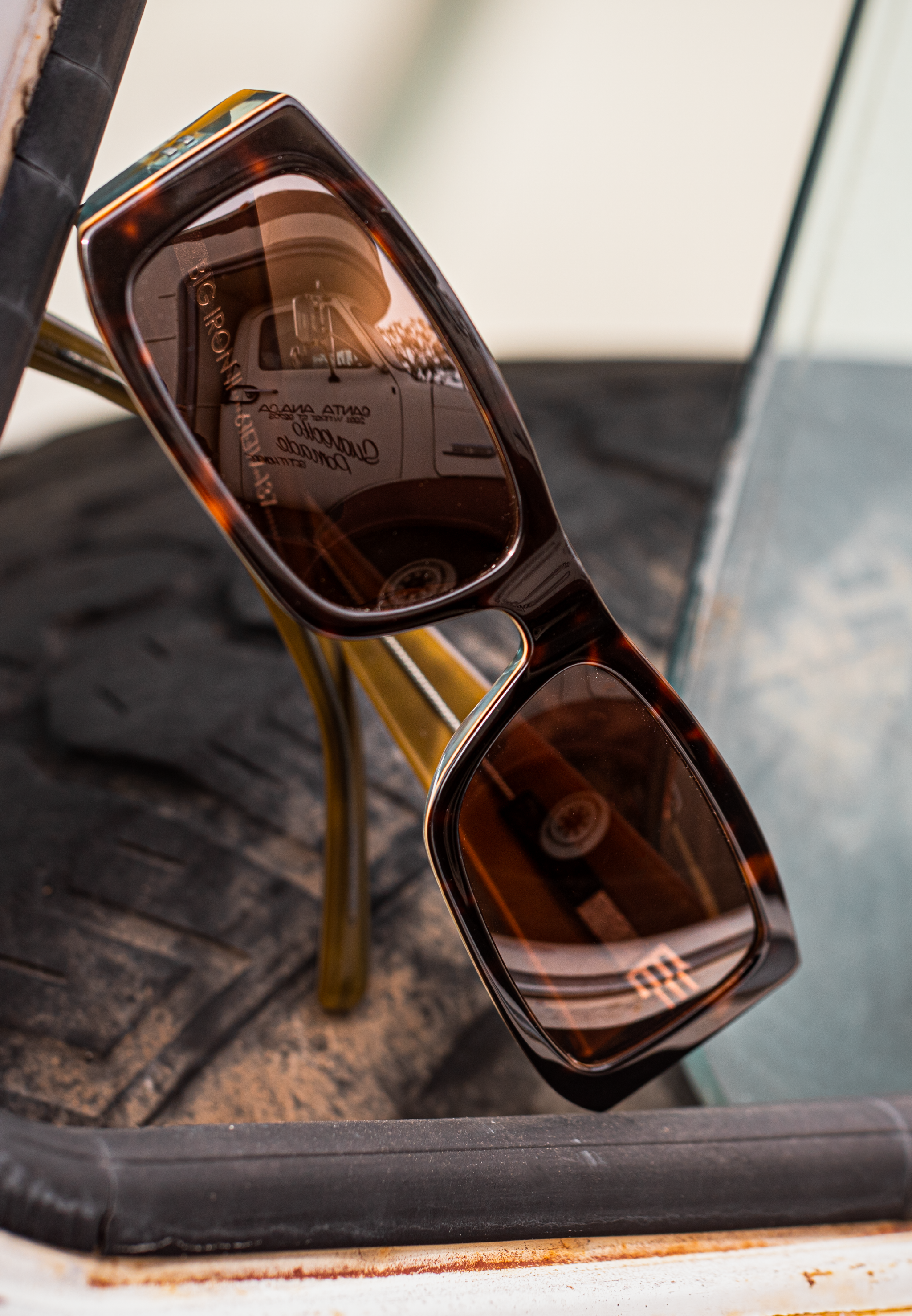 Tortoise Big Iron II sunglasses leaning at an angle on a distressed surface