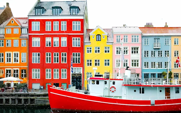A boat docked in front of colorful buildings.