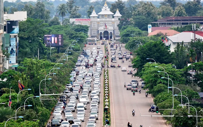 An aerial view of a busy street with cars and trees.