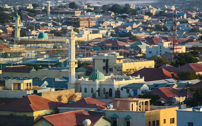 An aerial view of a city with a mosque in the background.