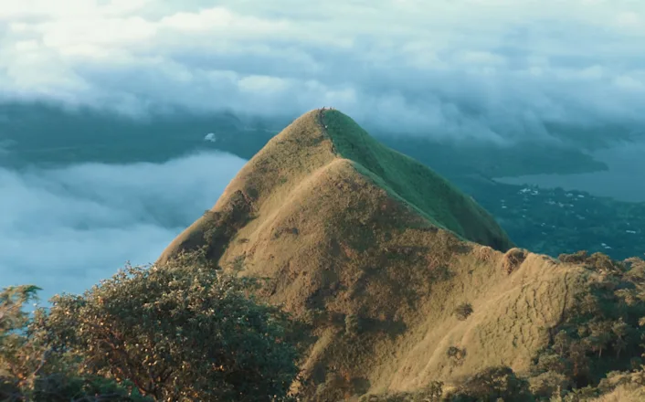 The top of a mountain with clouds in the background.