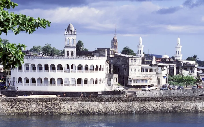 A white building next to a body of water.