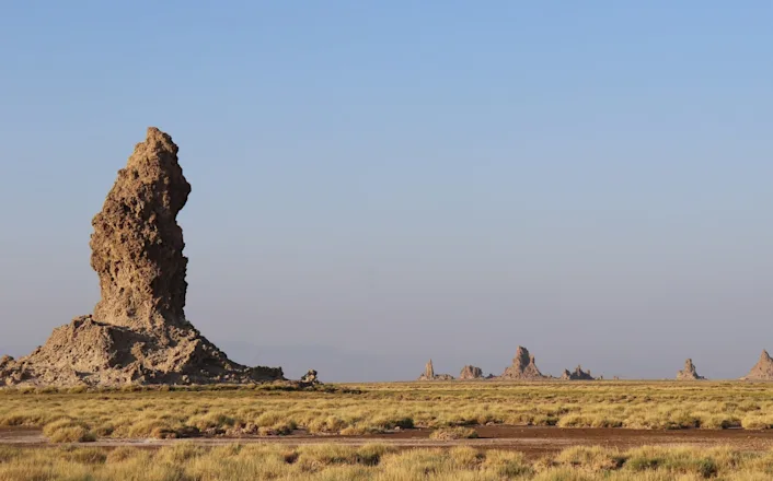 A large rock formation in the middle of a desert.