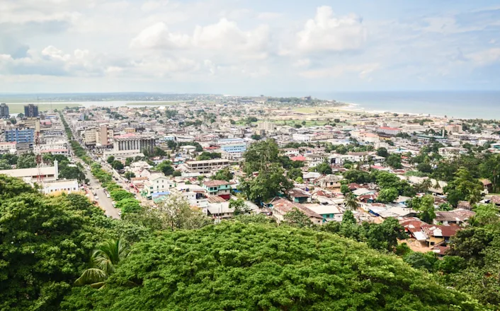A view of the city from a hill overlooking the ocean.