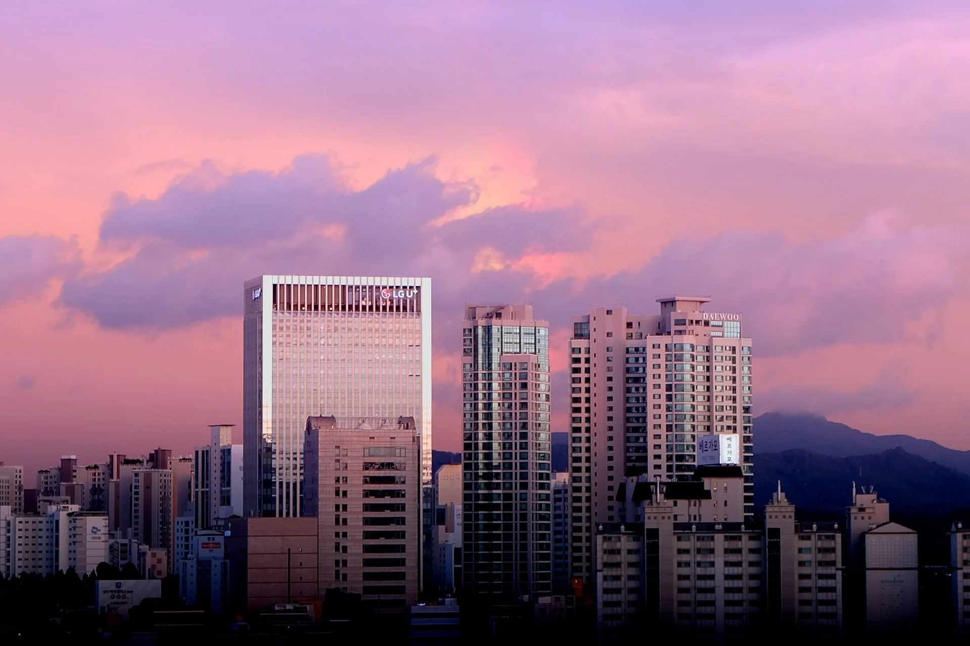 A city with tall buildings and a purple sky.