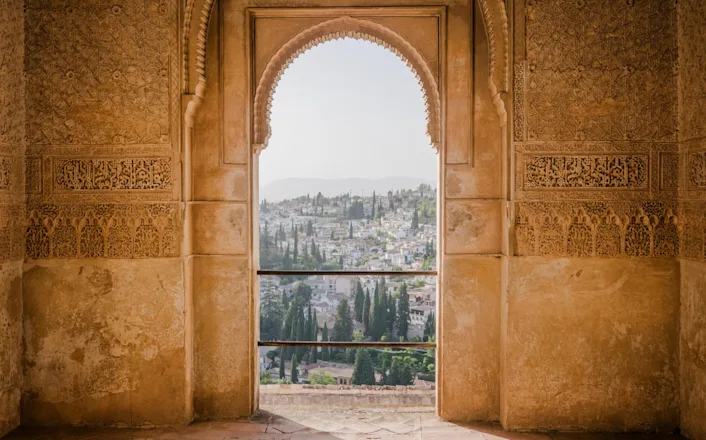 A view from an arched window in a building in granada, spain.