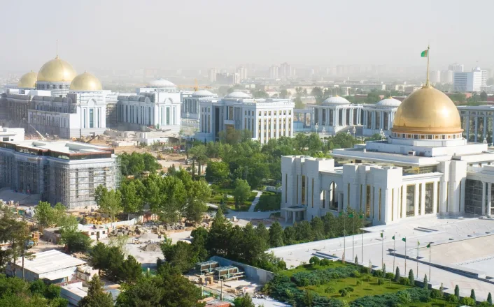 An aerial view of a white building with gold domes.