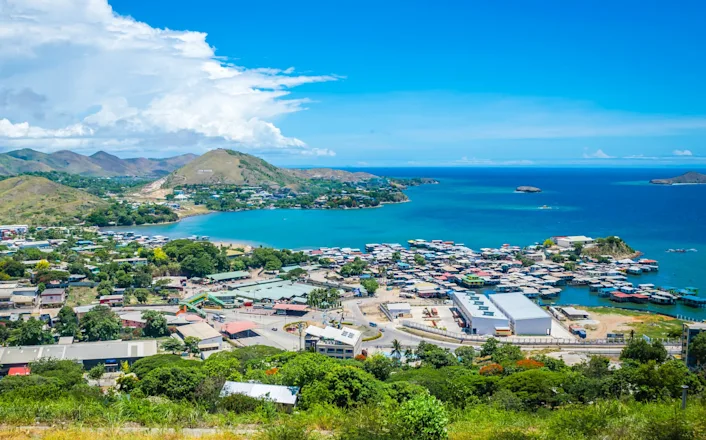 A small town on a hill overlooking the ocean.