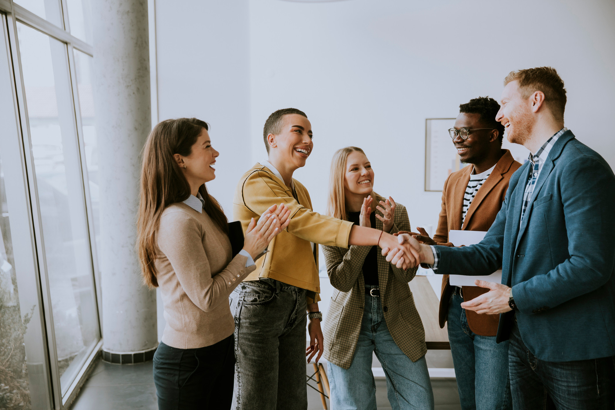 A group of business people shaking hands in an office.