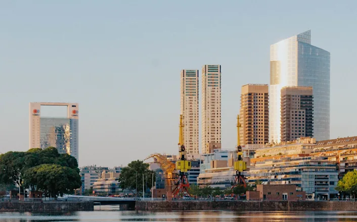 A city with tall buildings and a body of water.