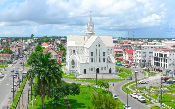 An aerial view of a white church in a city.