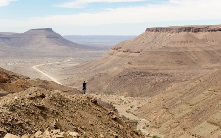 A person standing on top of a rocky mountain.