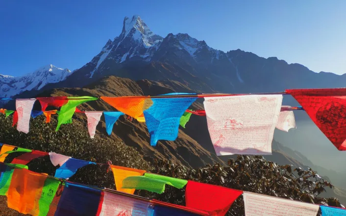 Prayer flags in front of a mountain with mountains in the background.