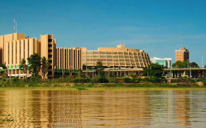 A tan building next to a body of water.