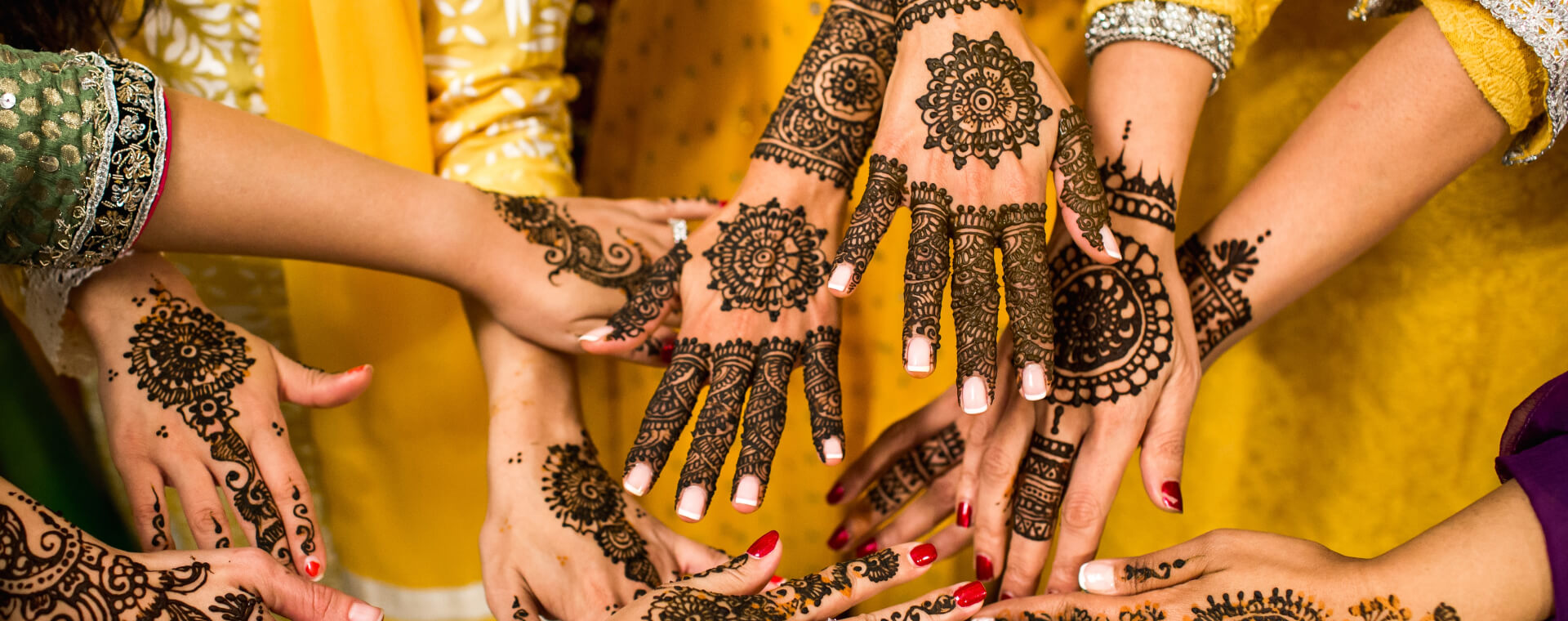 A group of women with henna tattoos on their hands.