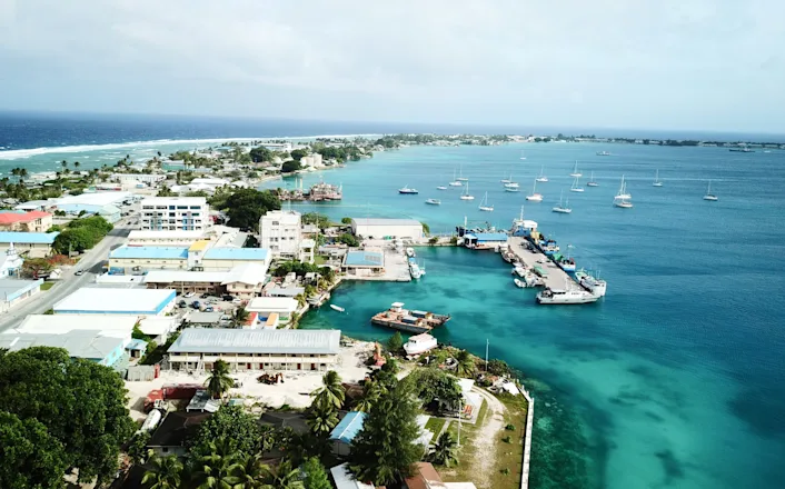 An aerial view of a town with boats in the water.