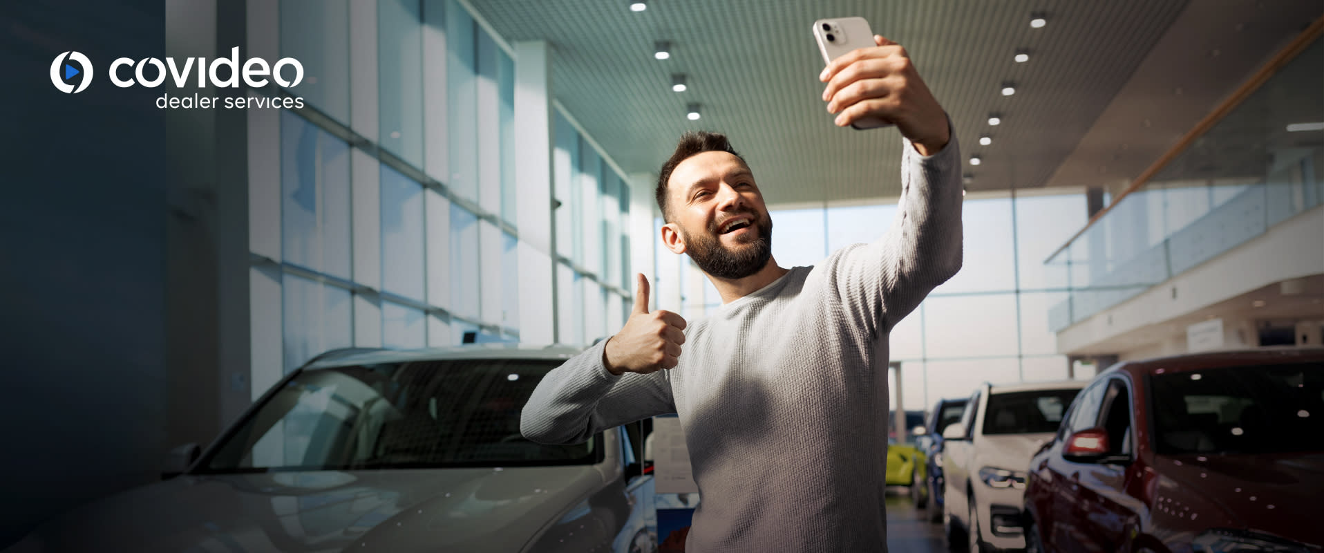 A customer takes a selfie in a car dealership showroom, highlighting the effectiveness of using personalized video messages in sales emails. The image, featuring the Covideo logo, underscores how video content can create engaging and memorable customer experiences.