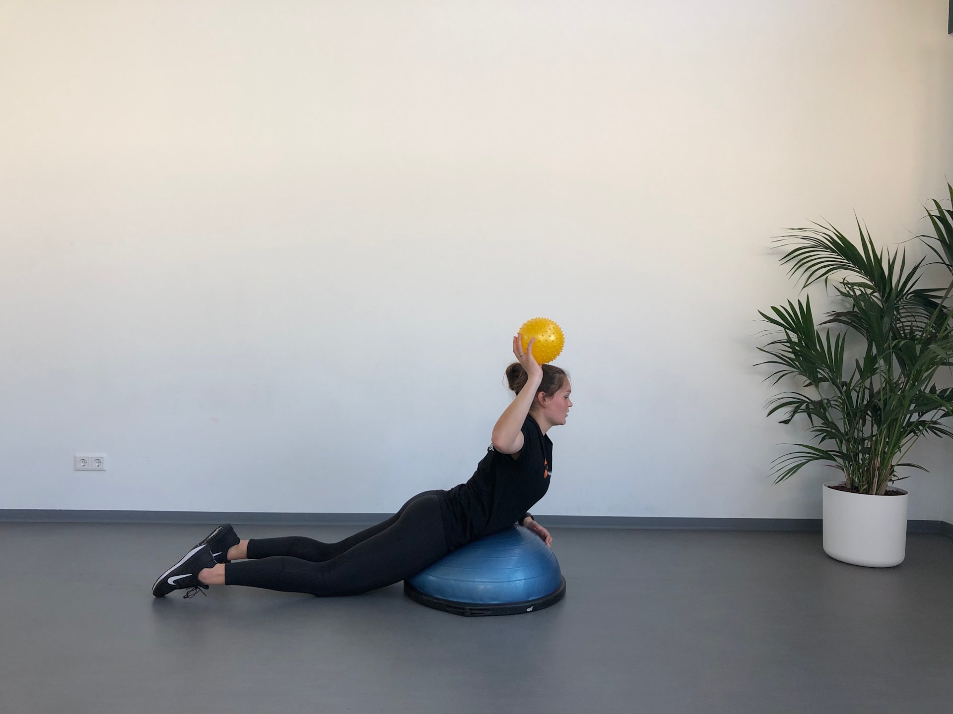 Uitstrekken bovenhandse worp bosu ball Schouder | In buiklig | Uitstrekken bovenhandse worp bosu ball | Fysioefening.nl | Breda