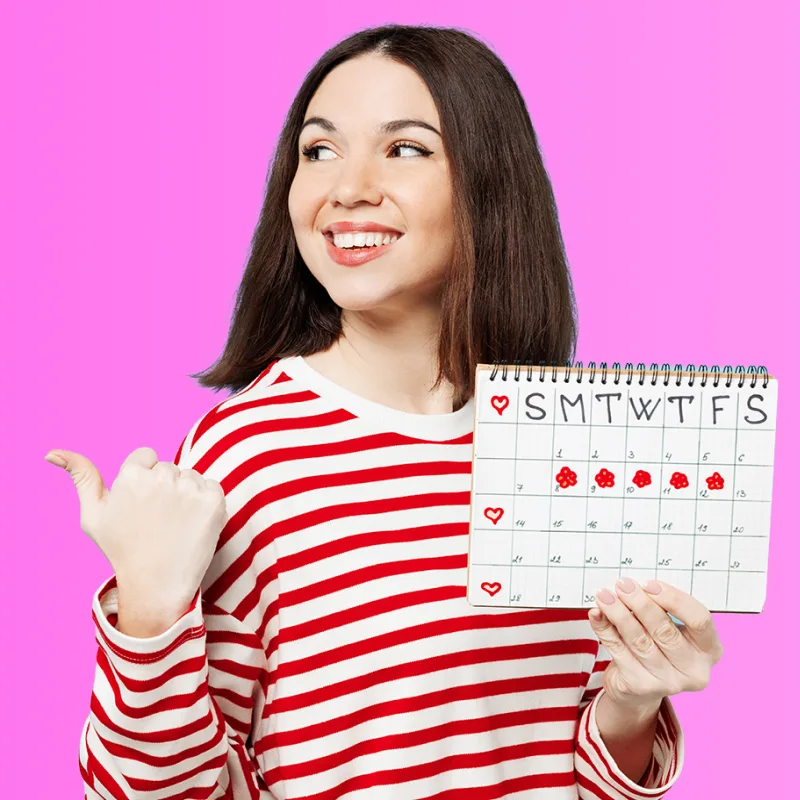 Smiling woman looking down at her smartphone using a period tracker
