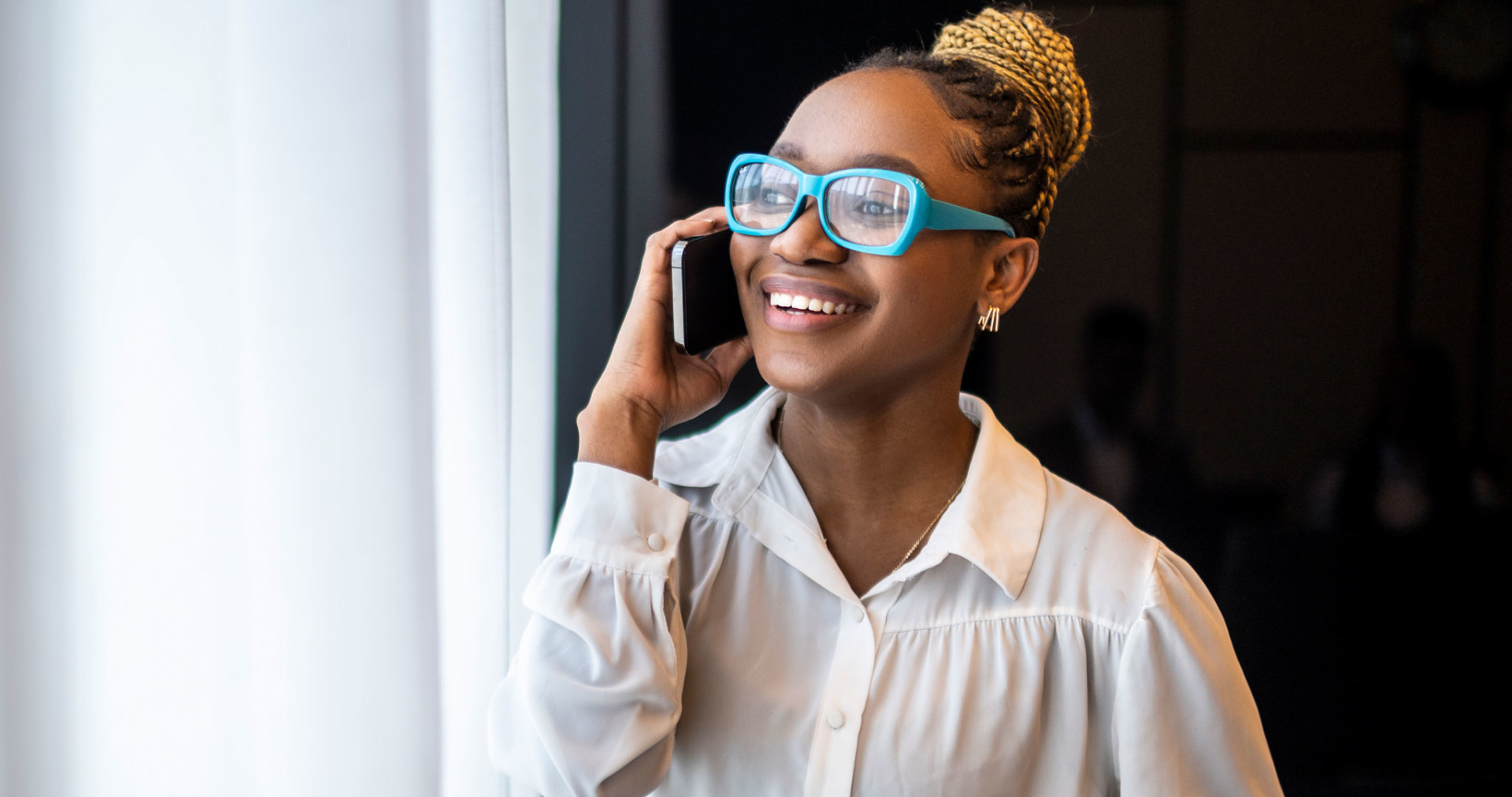 Young woman holding phone to her ear.