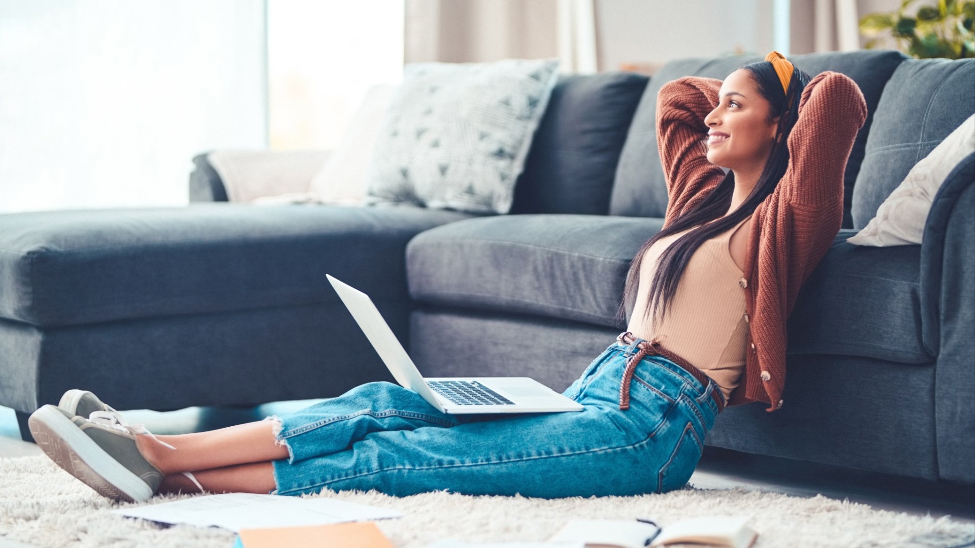 Woman in the living room sitting on the floor and feeling relaxed.