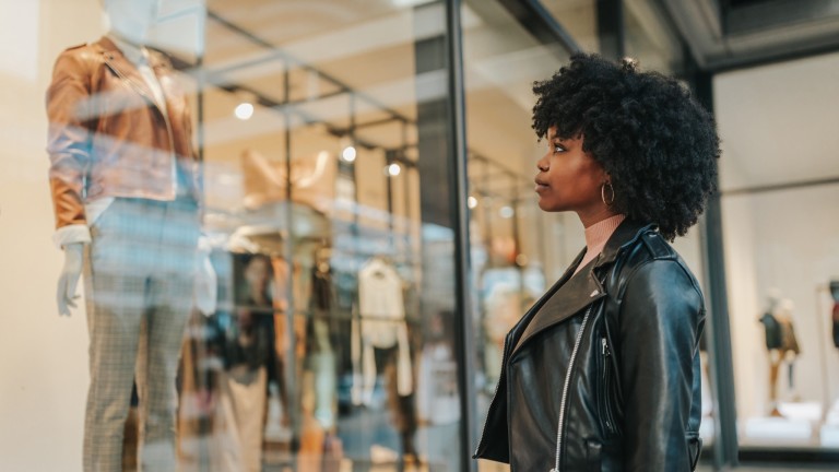 Woman standing in front of a shop window.