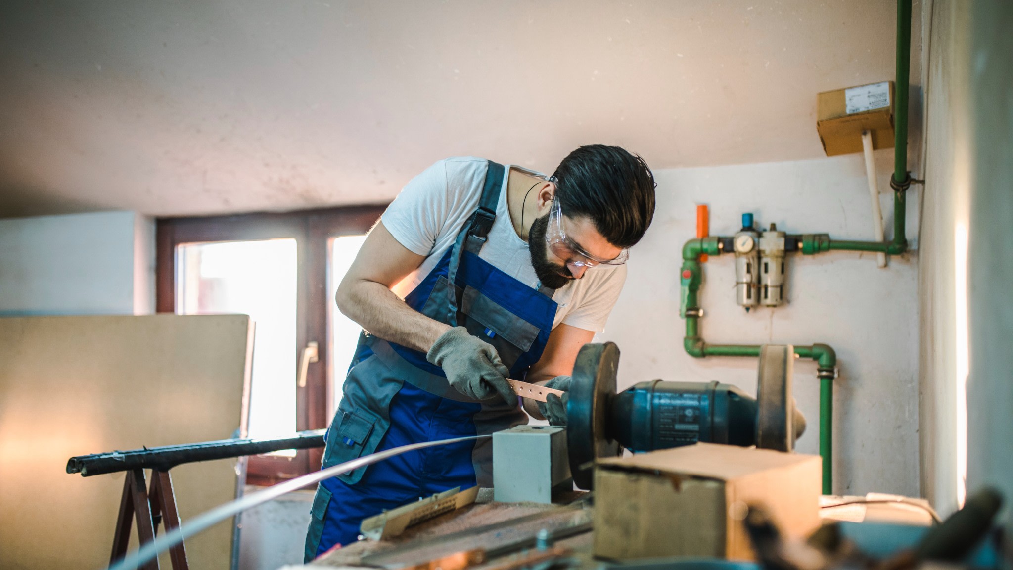 A man at a workshop using tools.