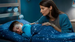 Mulher observa filho dormindo
