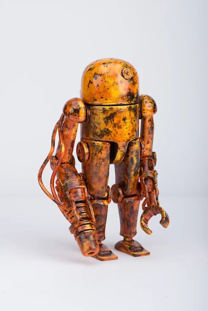 Robot figure painted to look like rusted, weathered orange metal