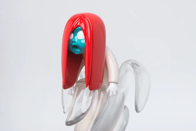 Close-up of a character figure with glossy red hair, a teal face and a frosted clear body