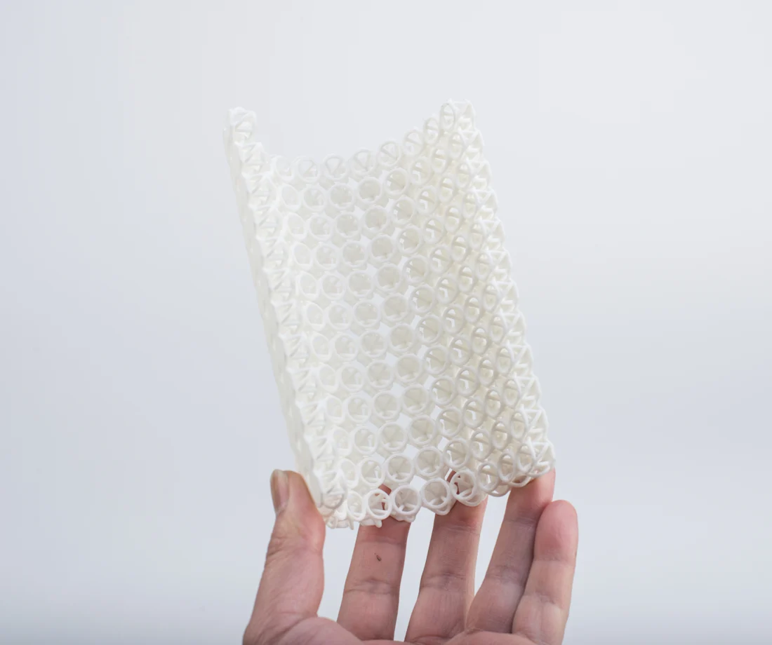 A white nylon PA12 sample showing detailed printed geometry