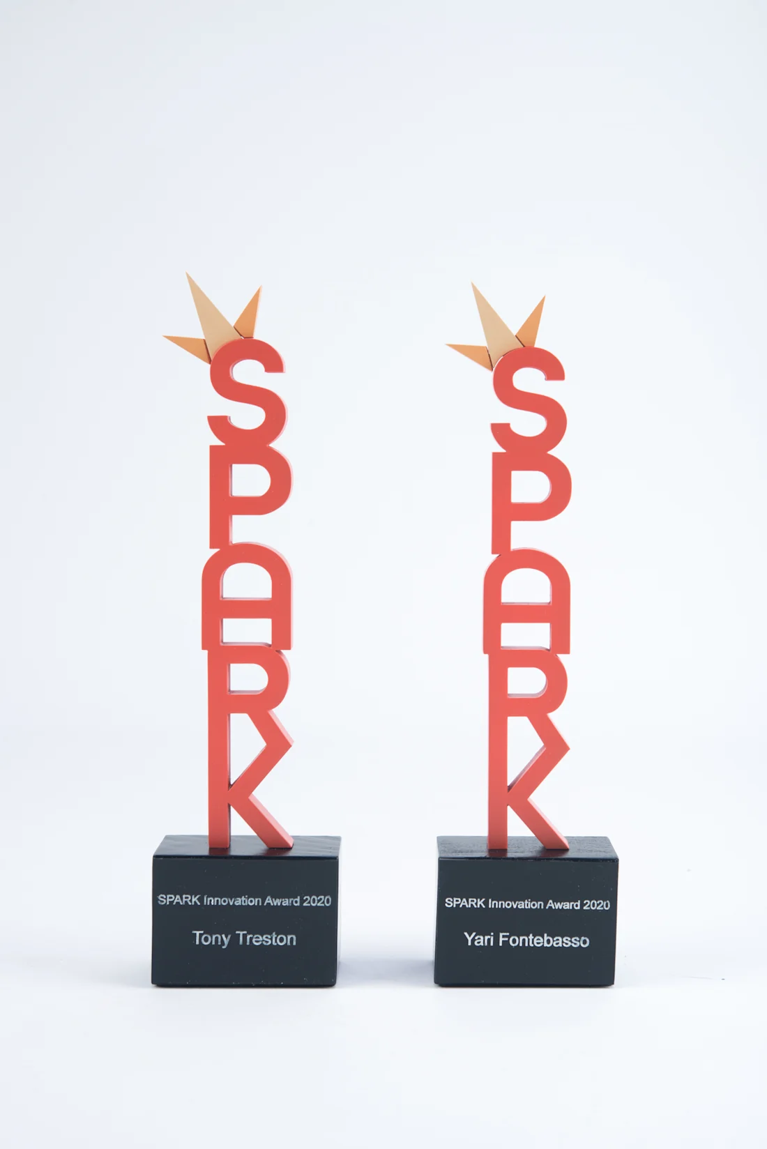 Two tall red Spark trophies with gold stars on personalized black bases