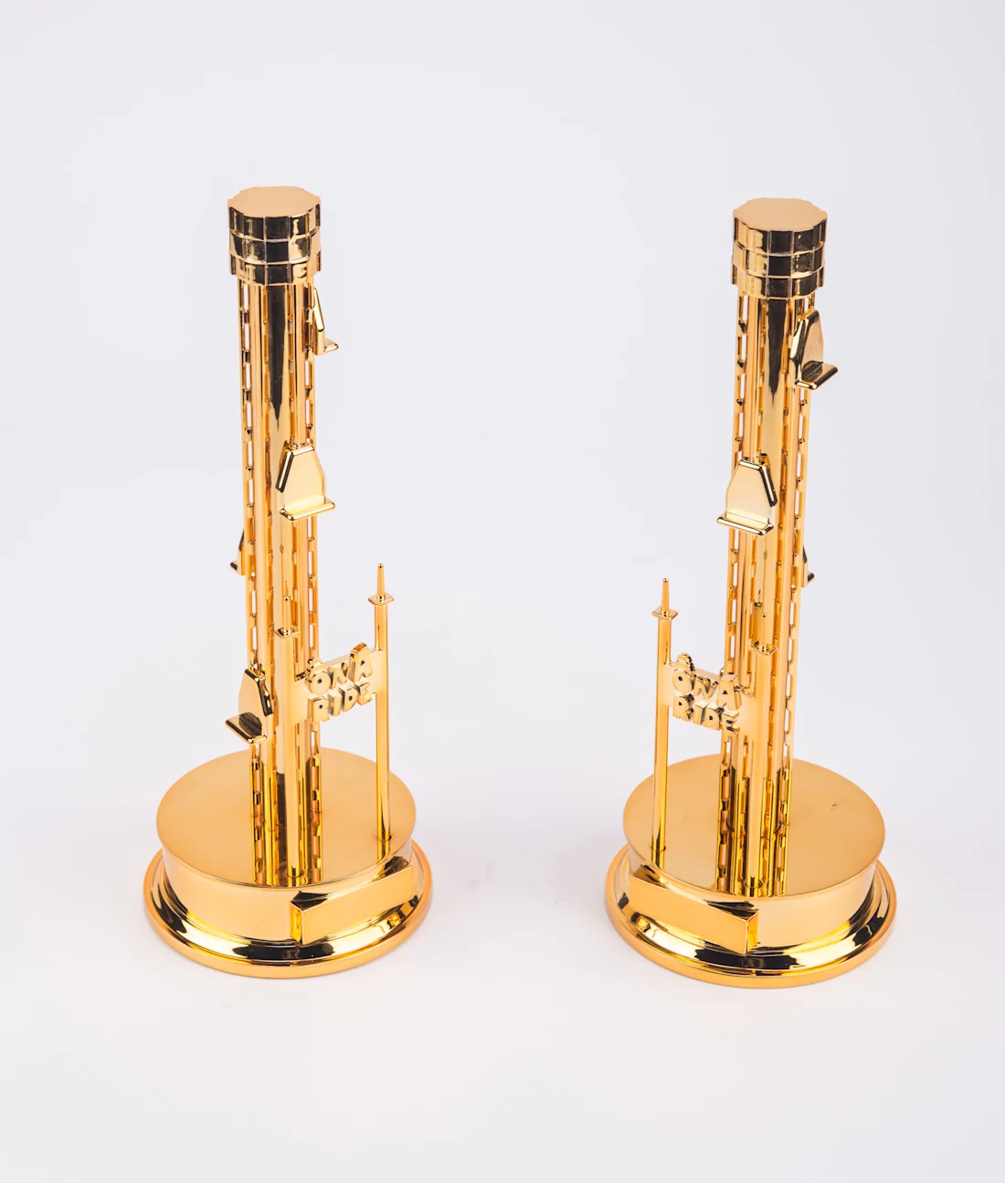 Two tall gold-plated tower awards on round gold bases