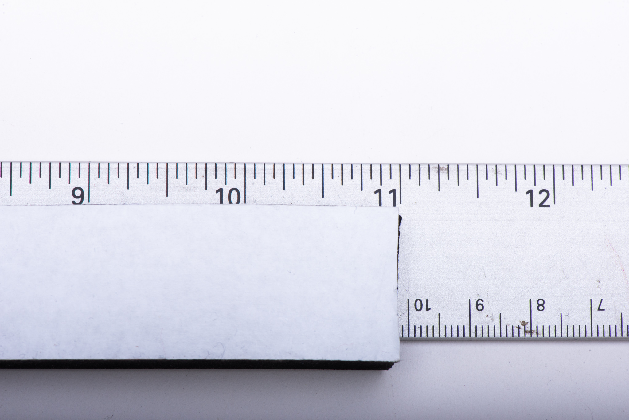 A ruler measuring a foam strip at the 11" mark
