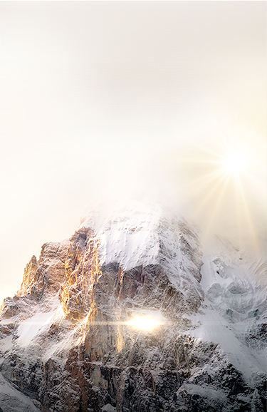 太陽の光を浴びた壮大な冬山