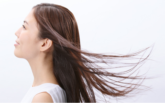 長いサラサラ髪が風になびいている女性の横顔