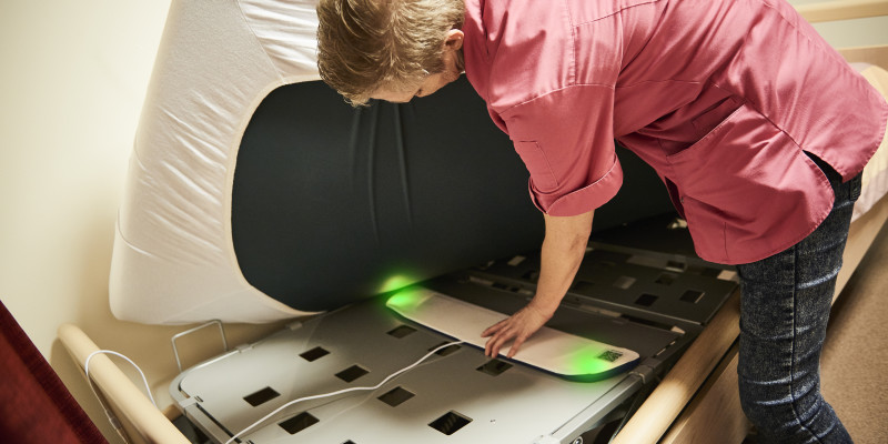 De Momo BedSense ligt onder het bed en geeft informatie over het slaapgedrag van een cliënt