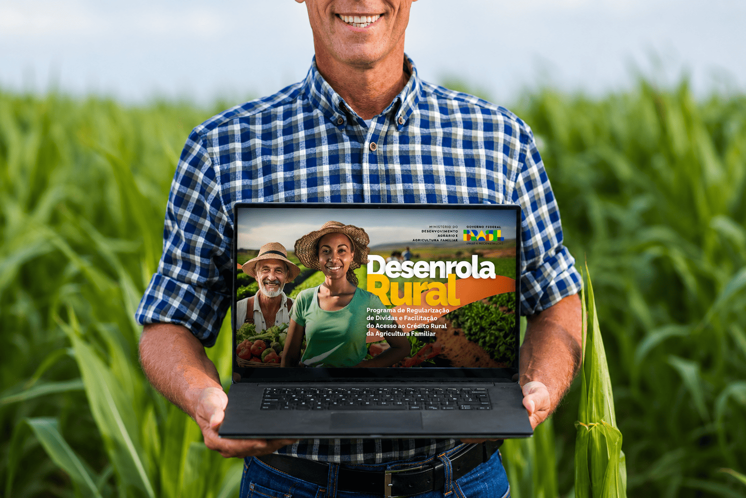 Agricultor segura notebook com o site do programa Desenrola Rural aberto na tela