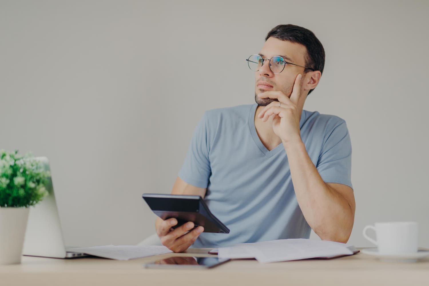 Empreendedor faz cálculos em sua mesa de escritório Empreendedor faz cálculos em sua mesa de escritório