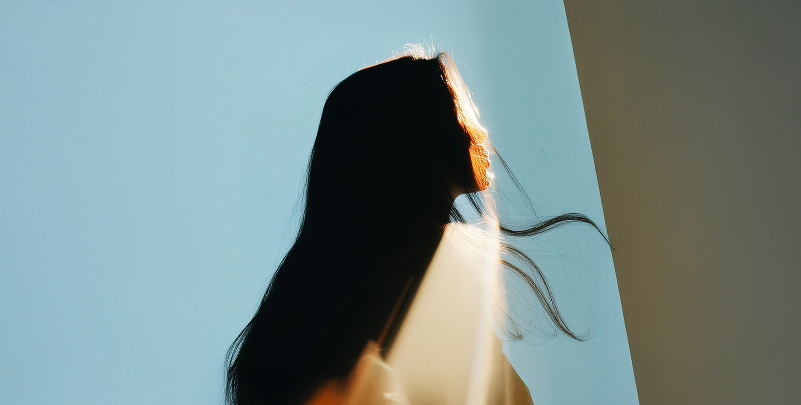 Silhouette of a women in the Light with blue sky Background