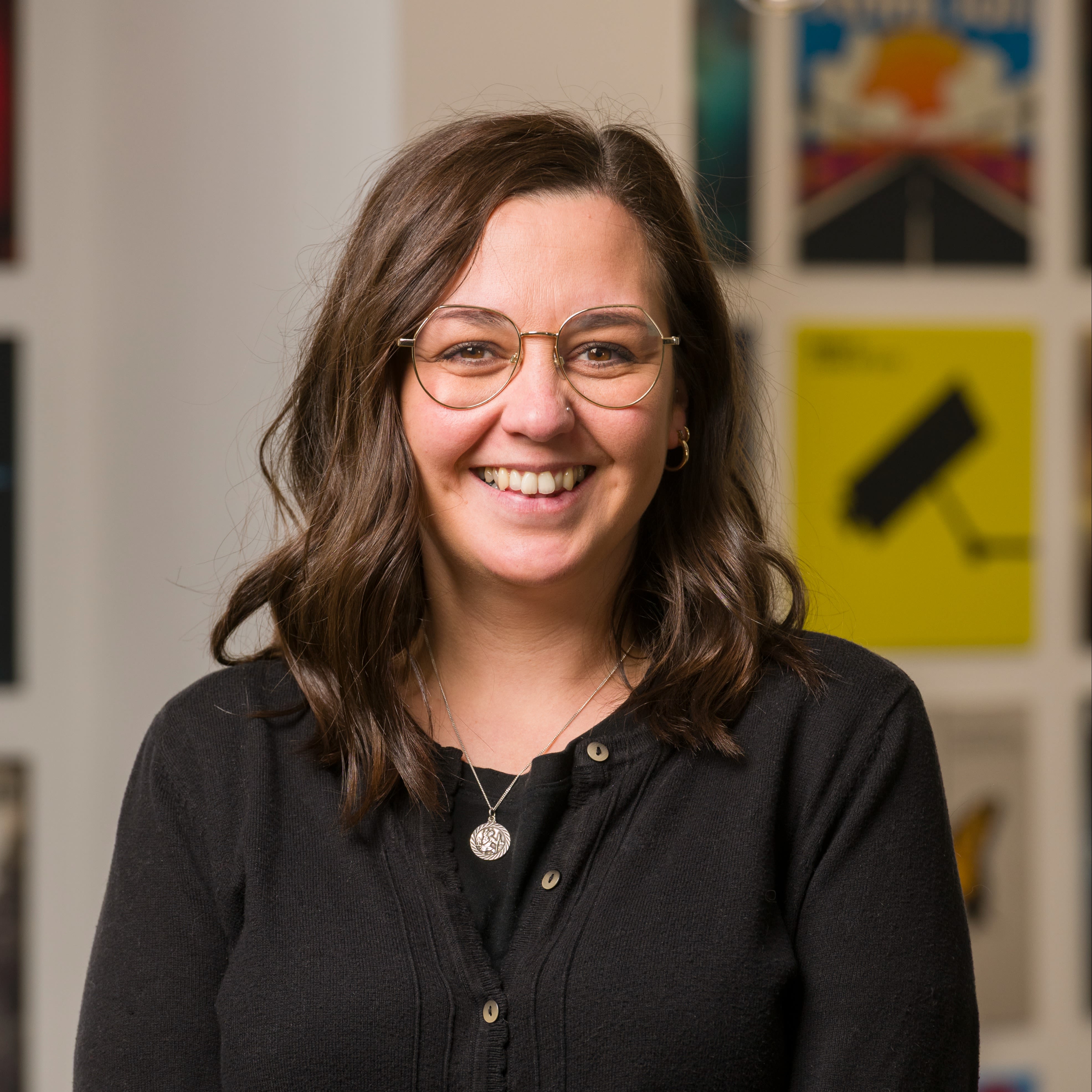 Smiling dark haired woman wearing a black top.