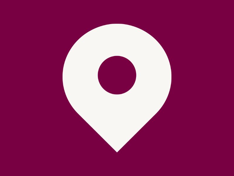White location pin icon on a plum coloured background.